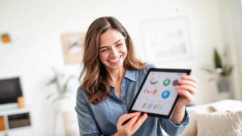 Mujer sonríe, gestiona finanzas con calma